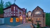 A view of a mini bavarian style village, with pink orange and red house lit up at night