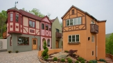 A pink and Orange bavarian style house with red trim dit quaintly side- by- side