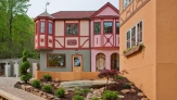 A pink and Orange bavarian style house with red trim dit quaintly side- by- side