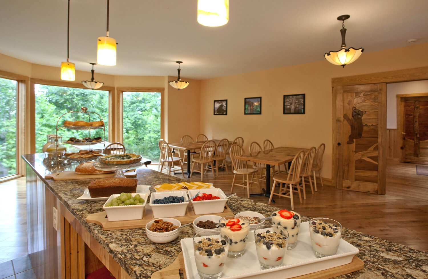 Delicious yogurt parfaits and other fruit and goodies rest on the buffet in this warm yellow dining room